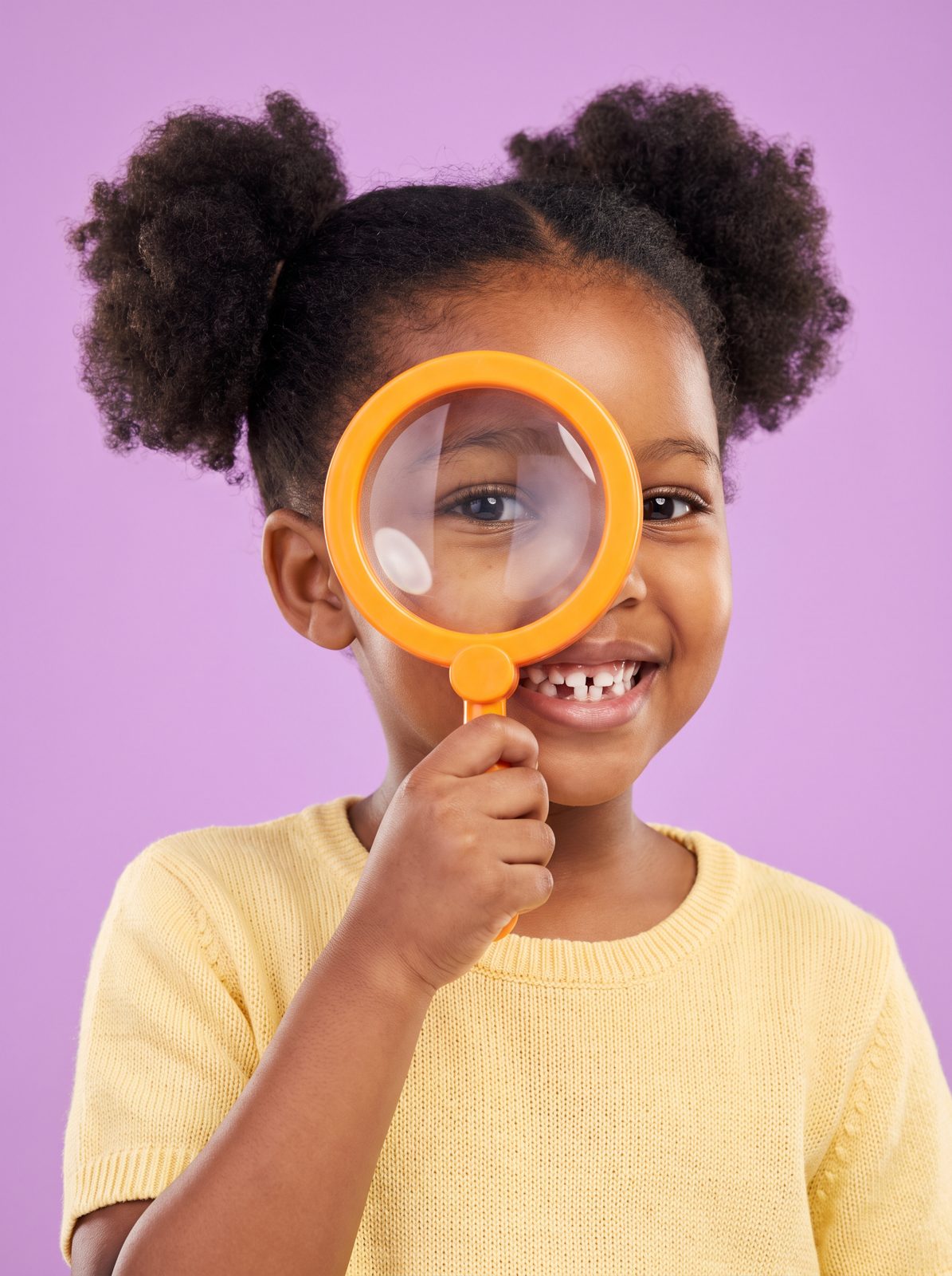 Girl looking through a magnifying glass