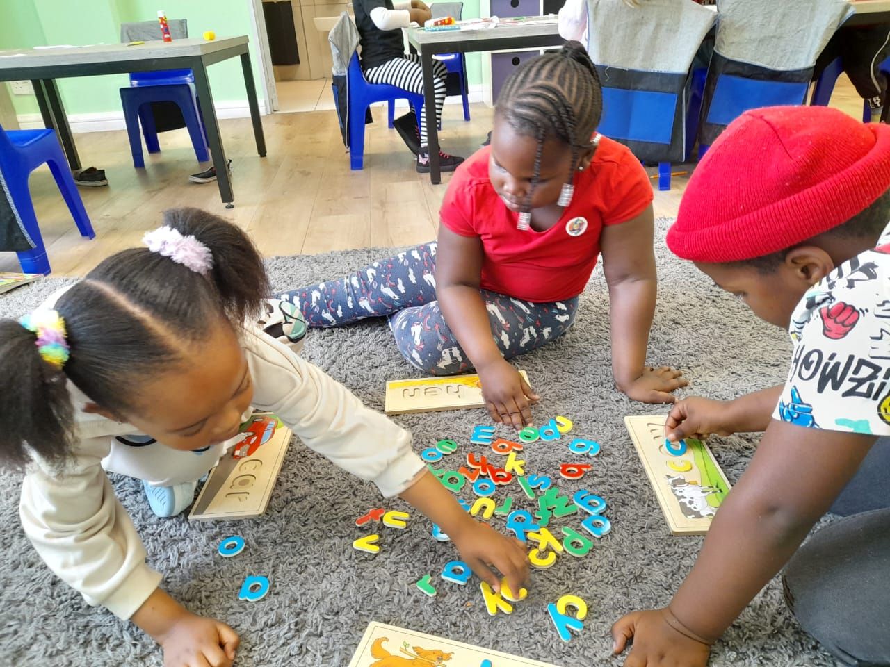 Children sorting wooden letters on the mat