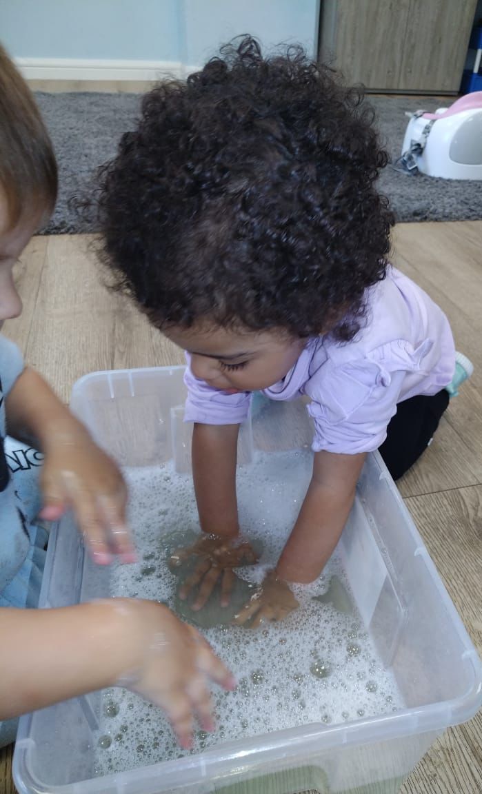 Toddler exploring a sensory tub